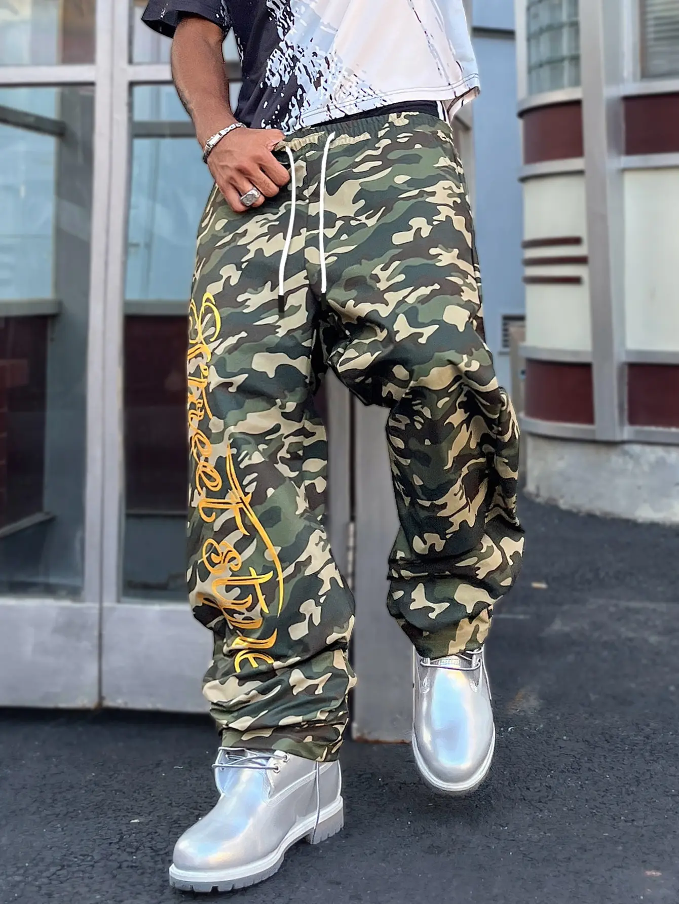 Men’s camo print baggy parachute pants with gold lettering and drawstring waist, street-style hip hop joggers, casual streetwear wide-leg trousers for men, camouflage sweatpants with yellow embroidery and drawstring waist for men Menswear Overall